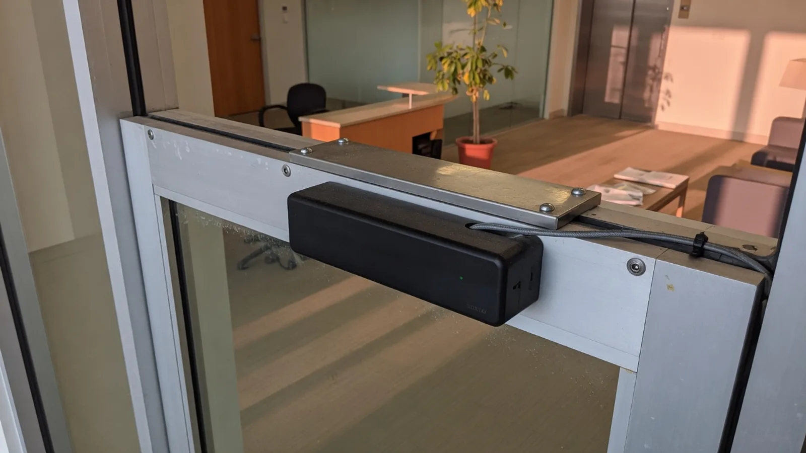 Electromagnetic maglock on an aluminum-and-glass commercial door in a San Diego office lobby